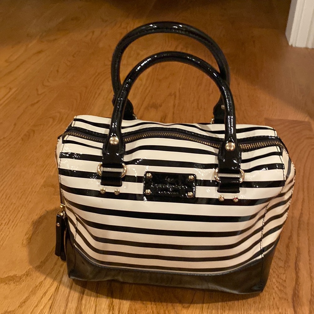 Black and cream patent leather kate spade handbag.